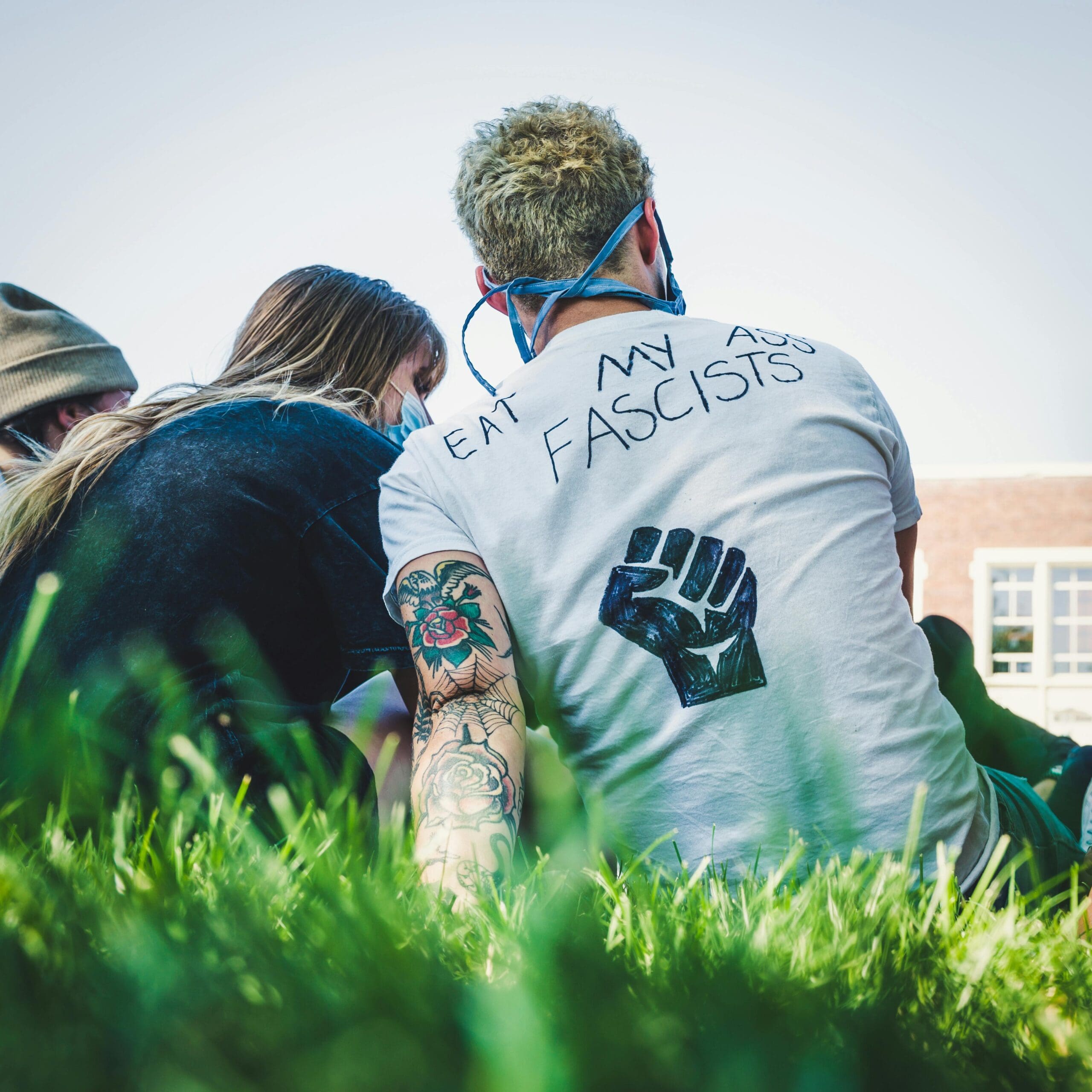 Anti-fascist protesters sitting in grass